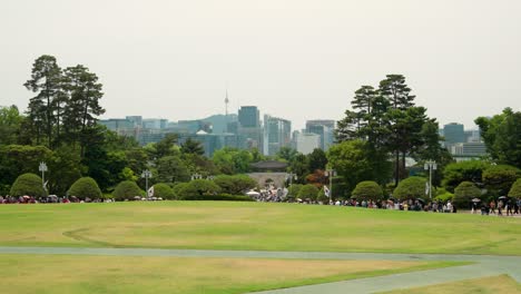 Gruppen-Von-Reisenden-Genießen-Es,-Im-Blauen-Haus-Cheong-Wa-Dae-Mit-Dem-Namsan-Seoul-Tower-Und-Wolkenkratzern-Im-Hintergrund-Herumzulaufen