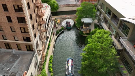 Tourists-on-boat-barge-enjoy-San-Antonio-River-in-downtown-urban-park-setting