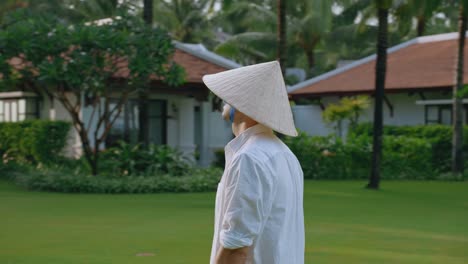 Un-Hombre-Mirando-Alrededor-De-Un-Resort-Tropical-Con-Arquitectura-Indochine-En-Agradables-Bengalas-Solares