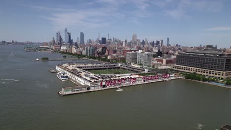 Aerial-view-around-Pier-40-at-Hudson-River-Park,-in-sunny-New-York,-USA---circling,-drone-shot