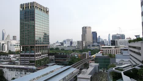 Cityscape-view-of-BTS-trains-passing-near-in-front-of-Asia-Hotel-in-Bangkok,-Thailand,-Southeast-Asia