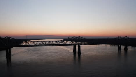 Low-aerial-shot-flying-over-the-Natchez-Vidalia-Bridge-on-the-Mississippi-River-at-sunset