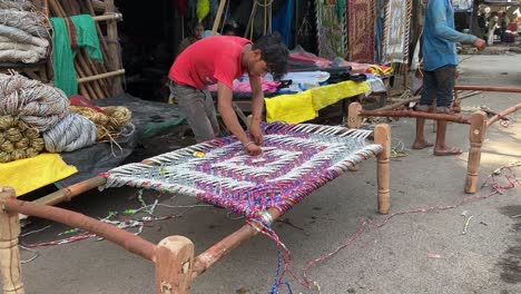 Un-Trabajador-Ata-La-Cuerda-Para-Preparar-Una-Cuna-De-Madera-Sostenible-Y-Asequible