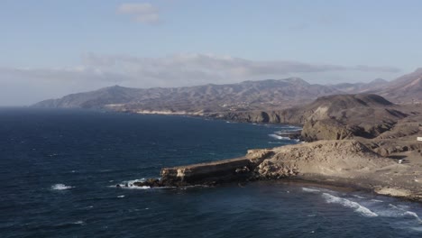 Dron-Aéreo-Cinematográfico-Que-Establece-Una-Toma-De-La-Pared,-Fuerteventura-En-Verano