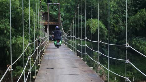 Puente-Colgante-Sobre-El-Río-Con-Cruce-De-Motocicletas-Por-La-Mañana-En-Sukabumi,-Java-Occidental,-Indonesia-El-4-De-Mayo-De-2022