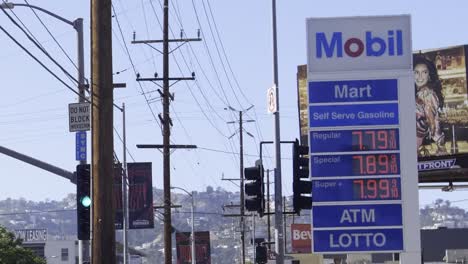 Cars-driving-in-Los-Angeles,-CA-past-a-gas-station-with-some-of-the-most-expensive-prices-in-the-United-States-due-to-inflation