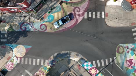 Top-down-aerial-shot-of-colorful-sidewalk-murals-on-quiet-city-street