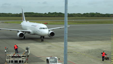 Ground-crew-guides-Air-France-jet-to-parking-gate-at-Brest-Airport,-France