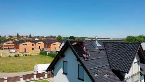 Trabajadores-Que-Trabajan-En-El-Techo-Instalando-Paneles-Solares---Vista-Aérea