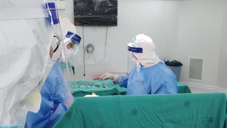 Asian-Surgeon-Wear-PPE-Perform-Upper-Body-Surgery-For-Contagious-Patient-In-Operating-Room