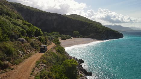 Car-driving-along-coast-road,-Gjipe-Beach,-Albania