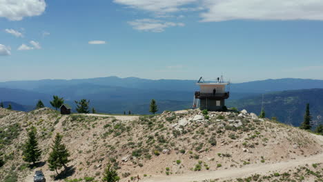 Aerial-circling-fire-lookout-on-top-of-mountain-with-people-on-lookout