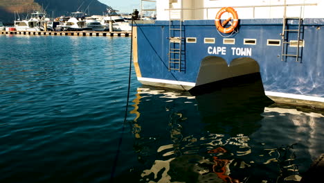 Reflexion-Im-Hafenwasser-Des-Touristischen-Sightseeing-Bootes-In-Der-Hout-Bucht