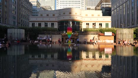 Canary-Wharf-London-England-Juni-2022-Stolze-Tributskulptur,-Die-Am-Cabot-Square-Brunnen-Steht,-Wobei-Die-Reflexion-über-Das-Wasser-Zurückgespielt-Wird