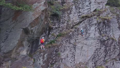 People-climbing-mountain-cross-rope-bridge-high-above-the-ground