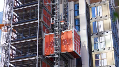 Canary-Wharf-London-England-August-2022-Tracking-Aufnahme-Des-Aufzugs,-Der-Die-Außenseite-Des-Neu-Gebauten-Turms-Nach-Oben-Bewegt,-Der-Für-Wohnungen-Entwickelt-Wird