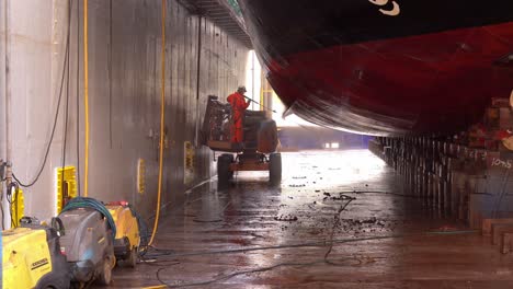 Trabajador-De-Astillero-Limpiando-Mejillones-Y-Suciedad-Del-Casco-De-Los-Barcos-Dentro-Del-Dique-Seco-Flotante---Westcon-Olensvag-Noruega