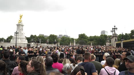 Crowds-of-people-gathering-in-front-of-Buckingham-Palace-mourning-and-paying-their-respects-to-Queen-Elizabeth-II-after-her-passing,-London,-England