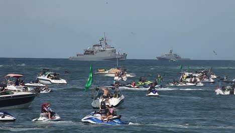 Kriegsschiffe,-Schlachtschiffe-Auf-Dem-Meer-Entlang-Des-Copacabana-Strandes-Mit-Menschen-In-Privaten-Motorbooten-Und-Jetskis-Schauen-Zu