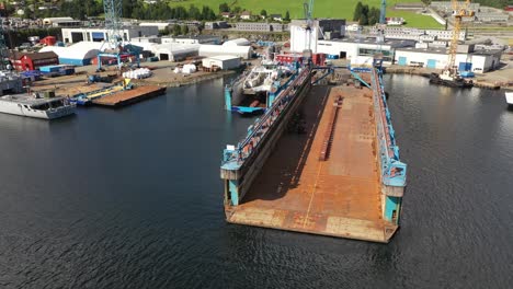 Dos-Diques-Secos-De-Astilleros-Flotantes-En-Westcon-Yards-Olen-Noruega---Hermosa-Vista-Aérea-De-Un-Enorme-Muelle-Vacío-Y-Un-Muelle-Más-Pequeño-Con-Ferry-Dentro