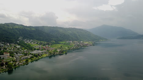 Vuelo-Sobre-El-Lago-Zug-En-Suiza-Con-Montañas-Al-Fondo