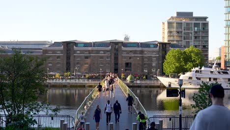 Londres-Inglaterra-Canary-Wharf-Agosto-De-2022-Vista-Del-Puente-Peatonal-Del-Muelle-De-La-India-Occidental-Mientras-La-Gente-Cruza-En-Una-Cálida-Tarde-De-Verano