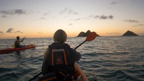 Paar-Paddeln-Kajaks-Auf-Dem-Meer-In-Richtung-Sonnenuntergang,-Hawaii,-Zeitlupe
