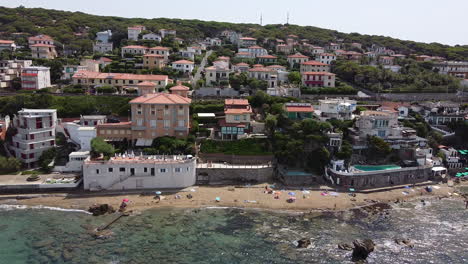 Descending-Aerial-view-of-Hotel-Baia-del-Sorriso-at-Quercetano-coastline-during-a-sunny-summer-day