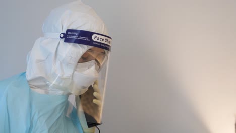 Medical-Staff-Wear-PPE-and-Face-Shield-Answer-The-Phone,-Close-Up