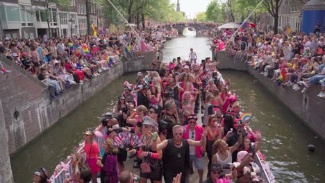 Amsterdam-Canal-Pride-Parade-Mit-Menschen,-Die-Auf-Booten-Tanzen-Und-Menschenmengen-Jubeln