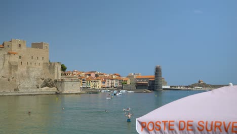 Beautiful-beach-view-in-Collioure,-France,-with-people-playing-some-beach-volleyball