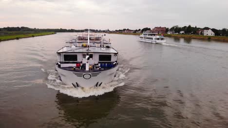 Aerial-Off-Forward-Bow-Of-Olympia-Cruise-Ship-Travelling-Along-River-Noord