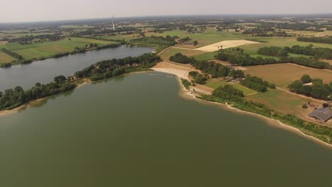 A-large-quarry-lake-flyover-heading-towards-a-radio-tower-in-the-distance-on-a-perfect-summer-day