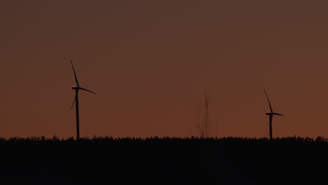 Wind-power-generator-turbines,-at-a-sunny,-evening-dusk,-in-Hoga-Kusten,-Vasternorrland,-Sweden