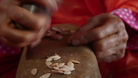 Close-Up-Of-Old-Woman's-Hands-Opening-Argan-Seeds-with-a-Rock