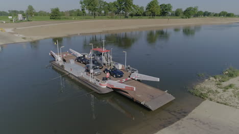 Ferry-with-several-cars-and-people-on-it-crossing-a-river-on-a-sunny,-summer-day