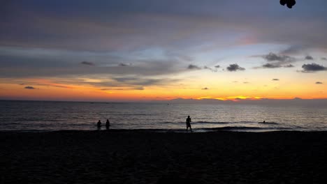 Silhouetten-Von-Menschen-Am-Strand-Bei-Sonnenuntergang,-Die-Frisbee-Spielen