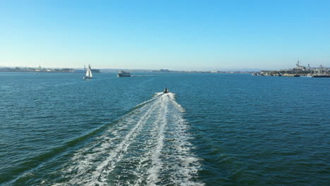 Aerial-view-following-a-speeding-fishing-boat-across-the-San-Diego-Bay