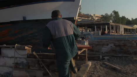 Pintor-Da-Un-Paso-Adelante-Para-Pintar-Un-Barco-De-Pesca-Griego-En-Tiempo-Real-De-Mano-Sol-Del-Puerto-De-La-Costa