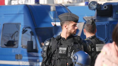 Police-officers-in-full-riot-gear-in-front-of-blue-police-tanks-in-the-middle-of-the-street-before-a-demonstration-in-Marseille,-south-of-France