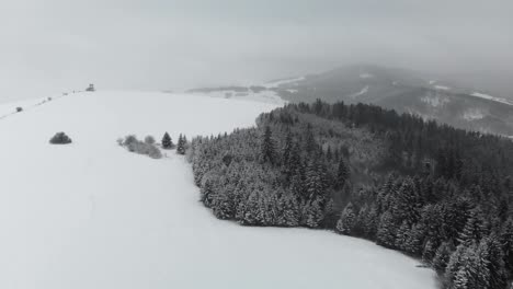 Antenne-Nach-Vorne-über-Schneebedeckte-Landschaft-Mit-Hügeln-Und-Schneesturm-Im-Hintergrund