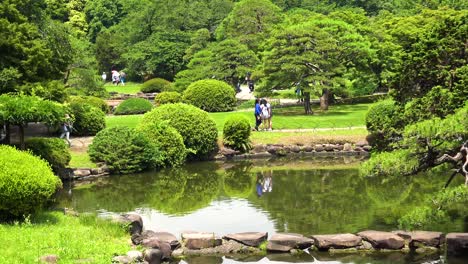 Der-Blick-Auf-Den-See-Mit-Völkern-Und-Baumreflexion-Im-Nationalgarten-Shinjuku-Gyoen