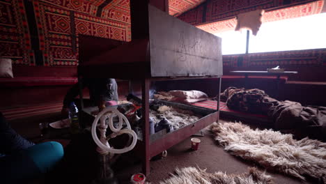 Two-Persons-Sitting-Next-to-a-Fireplace-Inside-the-Arabian-Decorated-Interior-Tent-on-a-Oriental-Ornamented-Carpet