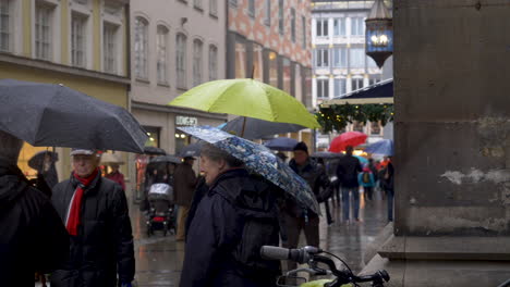 Gente-Caminando-Bajo-La-Lluvia-En-Una-Concurrida-Calle-Comercial-En-Munich