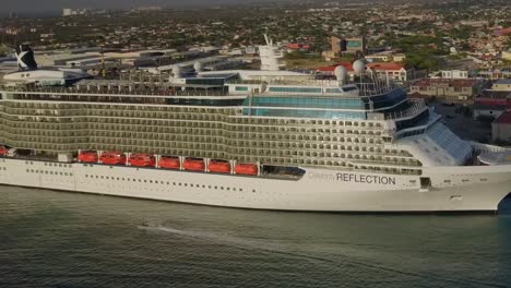 Aerial-shot-of-jet-ski-sailing-next-to-the-big-cruise-ship-in-dock-in-high-speed