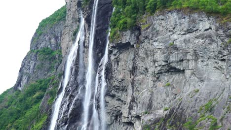 famous-waterfall-seven-sisters-in-Geiranger-Fjord,-in-Norway-seen-from-a-cruise-ship,-close-up-of-many-fast-moving-wild-waterfalls-tilt-shot-slow-motion