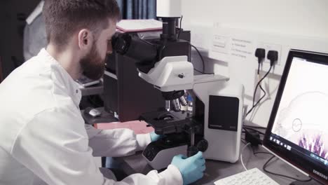 Looking-through-electron-microscope-in-lab