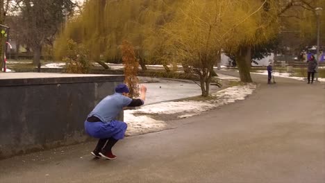 Man-does-a-back-flip-off-of-a-set-of-steps-leading-to-a-bridge-over-frozen-water-in-Cluj-Central-Park