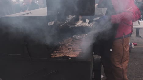 Zeitlupenclip-Eines-Mannes,-Der-Fleisch-Bei-Einer-Karnevals-Straßenfeier-Grillt