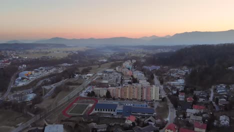 Drone-shot-of-a-beautiful-sunset-in-a-small-city,-town